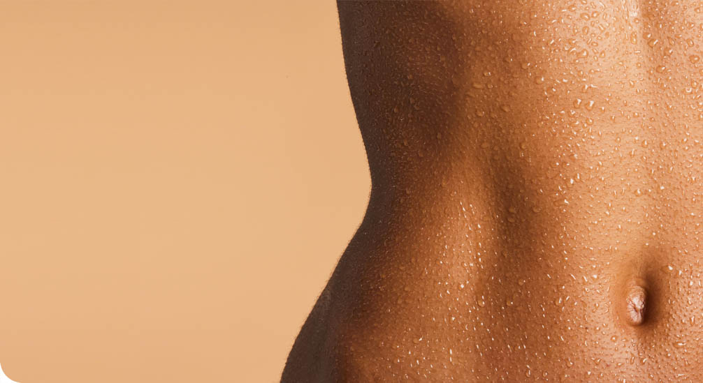 Close-up van de buik en navel van een persoon met een gebruinde, natte huid die bedekt is met waterdruppels.