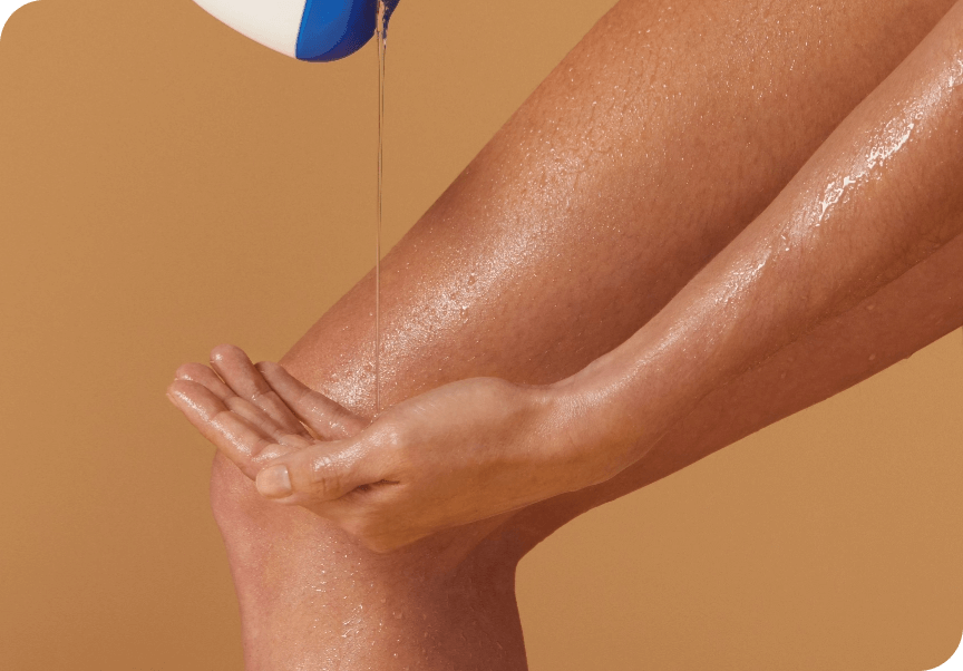 Iemand giet een heldere, olieachtige vloeistof uit een fles in de eigen handpalm boven glanzende benen.